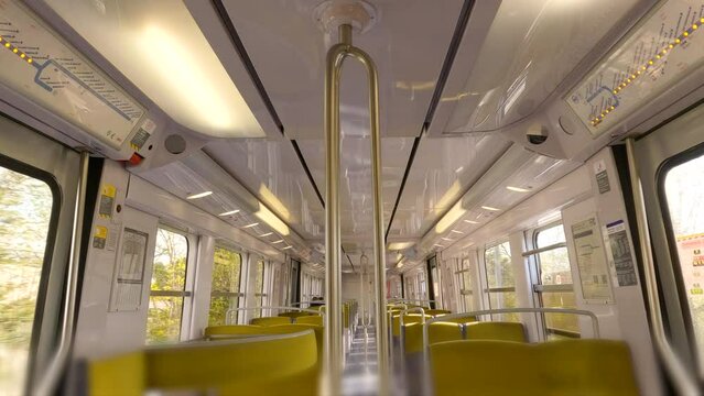Empty train. Empty windows seat in a train traveling through the city during the day. Moving empty train car. Interior of a passenger train with empty seats. 