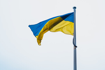 Flag of Ukraine on white sky background. National symbol of freedom and independence.