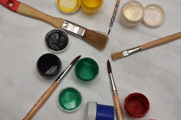 Multicolor watercolor paints and brushes on the surface of the material