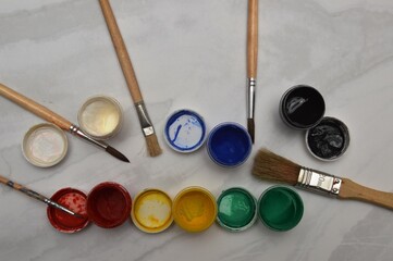 Multicolor watercolor paints and brushes on the surface of the material