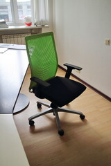 dark office chair lit by the sun against the wall