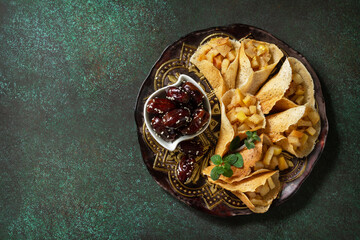 Ramadan kareem festive, fasting, halal food. Ramadan menu, arabian pancake katayef (katayev, qatayef) with apple filling and cinnamon. Top view, flat lay. Copy space.