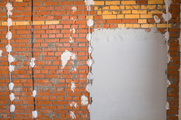 Industrial background. Structural plaster on the wall. Brick wall with plaster stains