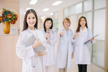 A group of medical professionals put their thumbs up and looked very straight at the camera with a friendly gesture.