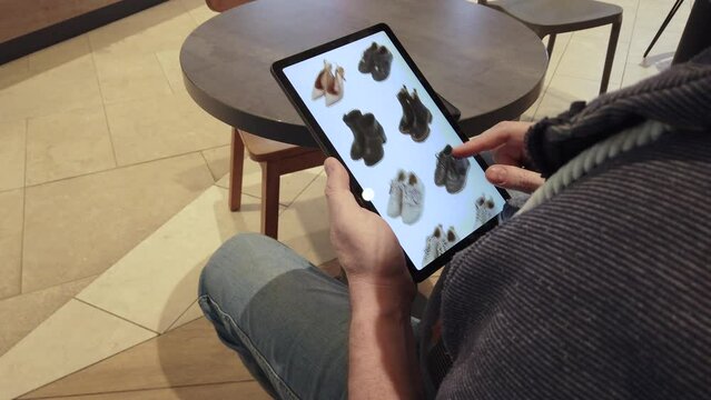 User interface application design, UI. Browse the range of shoes in the online store. View over the shoulder. Shopping online, payment and delivery concept