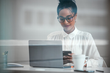 Shes here to make a name for herself. Cropped shot of an attractive young businesswoman sending a text while working at her desk in the office.