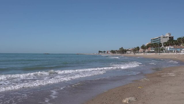 Villajoyosa beach Spain near Benidorm with palm trees sand and waves Costa Blanca Alicante