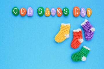 Odd socks day lettering and mismatched colourful socks on blue background. Social school bullying concept. Lost lonely socks. Top view flatlay idea for poster, banner, advertising