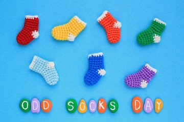 Odd socks day lettering and mismatched colourful socks on blue background. Social school bullying concept. Lost lonely socks. Top view flatlay idea for poster, banner, advertising