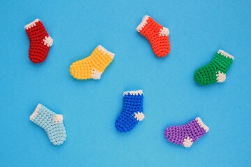 Christmas stockings hanging on blue background. Colorful rainbow socks. Odd socks day mismatched concept. Social school bullying. Top view flatlay idea for postcard with copy space for text. Close up