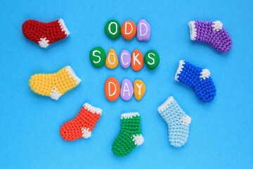 Odd socks day lettering and mismatched colourful socks on blue background. Social school bullying concept. Lost lonely socks. Top view flatlay idea for poster, banner, advertising