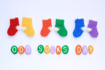 Odd socks day lettering and mismatched colourful socks on white background. Social school bullying concept.Lost lonely socks.Top view flatlay postcard for poster, banner, web, magazine