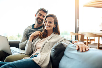 Great company is always rare to find. Portrait of an affectionate young couple using a laptop while relaxing on their sofa at home.