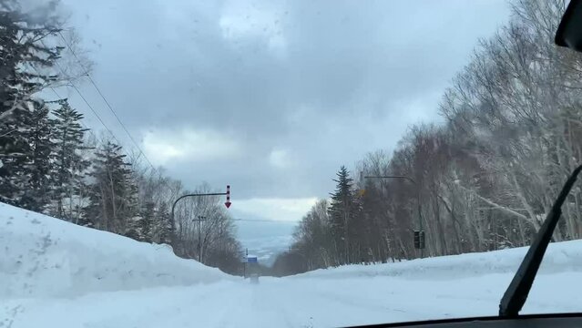 일본 홋카이도 비에이 눈쌓인 도로를 지나는 자동차, 차 안에서 찍은 정면 풍경 / A car passing through a snowy road in Bii, Hokkaido, Japan, a front view taken in a car 