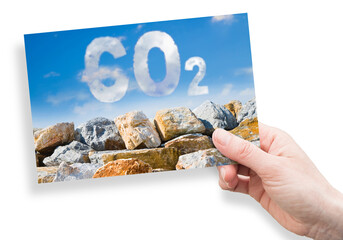 Fototapeta premium Protection from CO2 carbon dioxide emissions - concept image against a boulders wall on sky background - concept image with hand