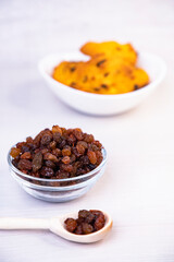 Cookies with raisins in a bowl, on a wooden background, baking. vertical frame