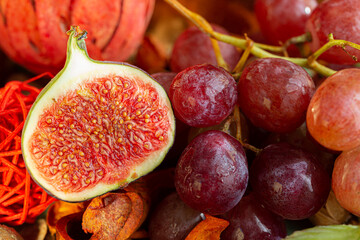 A fig cut in half on pink grapes. Sweet fruits. Shallow depth of field. Food.The artistic intend and the filters. Film style old lens. Macro, closeup.