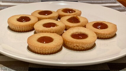 Cookies with red berry jam on a white ceramic plate