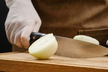 Person or chef cutting a onion. Cooking food. Sliced  onions. Shallow depth of field