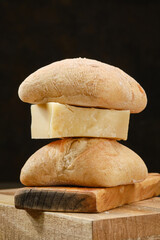 Traditional Italian hard cheese Parmesan or Grana Padano with white bread on a wooden cutting...