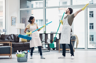 Chores can be fun done with the right one. Shot of a happy young couple having fun while mopping...