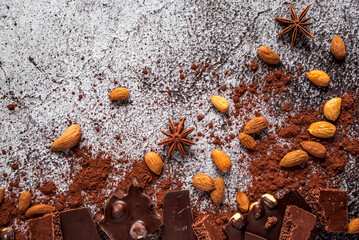 dark bitter and milk porous chocolate, cocoa powder, almonds, hazelnuts on a gray neutral concrete background 2