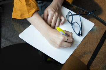 Hand of a young woman writing in a notebook. Concept: education.