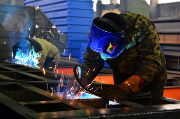 Fototapeta na wymiar the welder at the factory cooks the structure