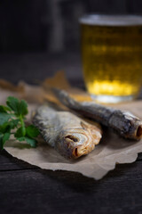 close up dried fish, vintage glass of beer on a dark wooden background. Top view.