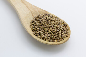 cannabis seeds on a wooden spoon on white background, copy space top view horizontal. Banner, cover, mockup, for your design