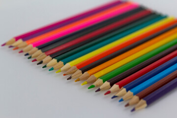 a row of coloured pencils on white background horizontal
