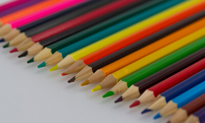 a row of coloured pencils on white background horizontal
