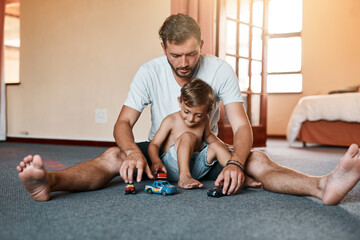 The ultimate father son bonding activity, playing with cars. Shot of a little boy and his father...