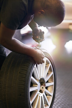 Fixing a tyre puncture. Cropped shot of a mechanic repairing a car tyre.