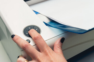 close up female hand pressing a button in the printer, copy space, business concept