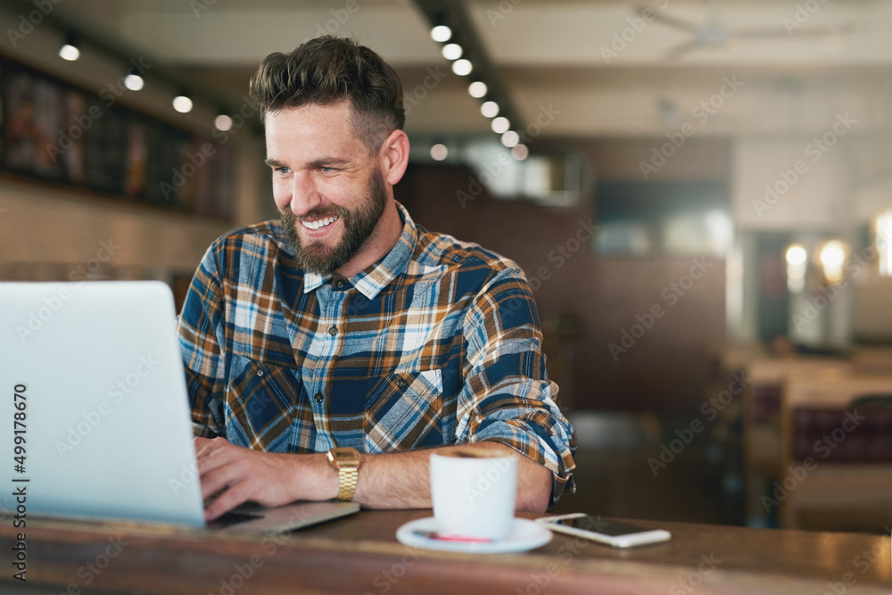 Poster coffee and cat videos - a classic combination. shot of a young man using his laptop while sitting by