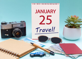 Travel planning, vacation trip - Calendar with the date 25 January glasses notepad pen camera cash passports.