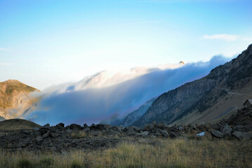 Sunrise or sunset high in the mountains, in a green valley and a clear sky with some clouds
