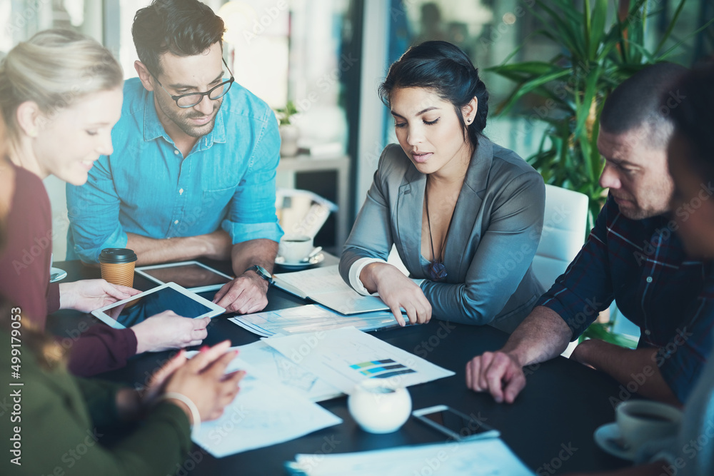 Wall mural Going over the paperwork. High angle shot of a group of businesspeople meeting in the boardroom.