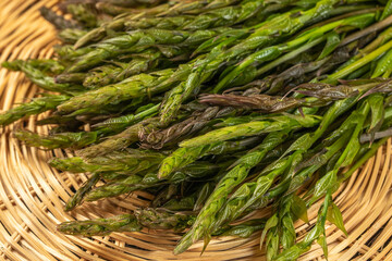 Forest asparagus on a brown background, wild asparagus, closeup, healthy food