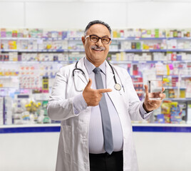 Doctor holding a glass of water and pointing in a pharmacy