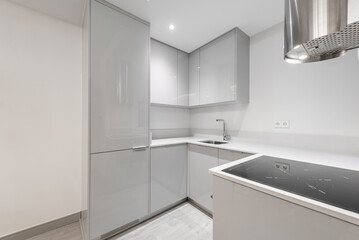 kitchen with white stone countertop, glossy gray cabinet column and stainless steel appliances and range hood