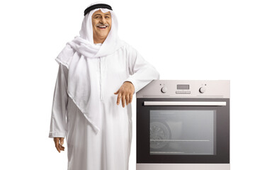 Mature arab man leaning on a built in oven and smiling