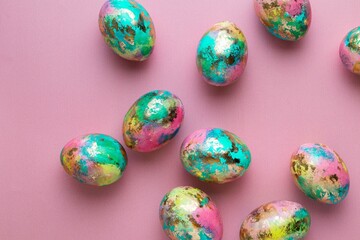 Minimalistic Easter composition. Golden paint eggs on pink background. Greeting trendy color concept. Top view, flat lay.
