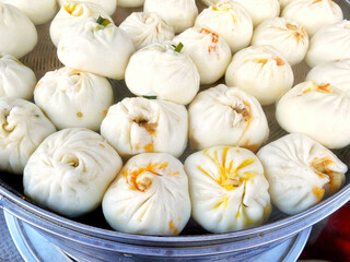 Steamed steamed buns in a cage, traditional Chinese breakfast food in Asian countries, rich in nutrition, with meat and greens fillings and various ingredients, various flavors
