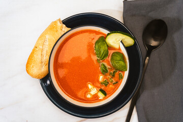 Modern white bowl with Andalusian Gazpacho. Vegetable and organic soup or cold drink that is drunk in summer.