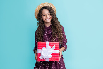 happy child with curly hair hold present box on blue background