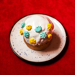 Plate with delicious Easter cake on red background