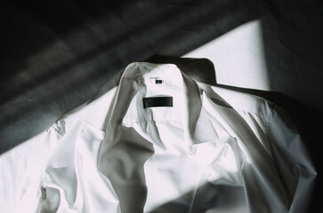 White shirt lying on the bed