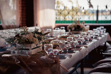 Decorated elegant wooden wedding table for banquet outdoor in garden gazebo
